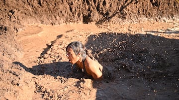 Una mujer pasa por un agujero lleno de barro durante la celebración de la Gran Canaria Bestial Race 2023 disputada el sábado 9 de diciembre en Arucas, Gran Canaria, España.