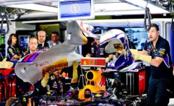 Los mecánicos de la escudería Red Bull trabajan en el monoplaza del alemán Sebastian Vettel en el garaje de su equipo durante la primera sesión de entrenamientos libres para el Gran Premio de España.