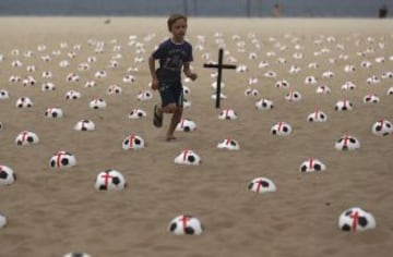 Miembros de la ONG Río de Paz colocan balones de fútbol marcados con cruces rojas como protesta en la playa de Copacabana en Río de Janeiro. La protesta fue un llamado al gobierno para que los servicios de educación, salud pública y para lograr los mismos estándares que los estadios de la Copa Mundial de la FIFA, de acuerdo con la Organización.