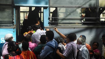 Commuters rush to catch a public bus without maintaining social distancing despite fears over the spread of the Covid-19 coronavirus, in Kolkata on September 21, 2020. (Photo by Dibyangshu SARKAR / AFP)