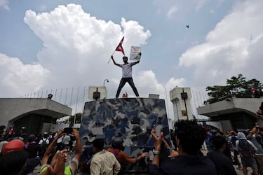 Un manifestante ondea una bandera mientras se encuentra de pie sobre un vehículo cerca de la entrada del Parlamento durante una protesta contra la corrupción y la decisión del gobierno de bloquear varias plataformas de redes sociales, en Katmandú, Nepal.