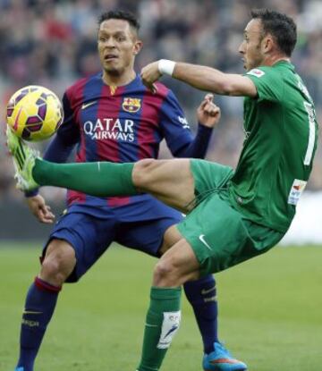 El centrocampista del Levante Jordi Xumetra intenta controlar el balón ante el defensa brasileño del FC Barcelona Adriano Correia, durante el partido de la vigésimo tercera jornada de liga de Primera División.