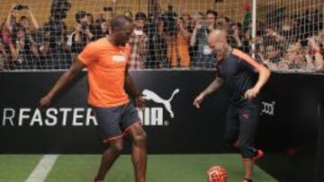 El jamaicano Usa&iacute;n Bolt, campe&oacute;n ol&iacute;mpico y mundial de 100 y 200 metros planos, y el delantero del equipo mexicano de f&uacute;tbol Am&eacute;rica, Dario Benedetto (d), dan una exhibici&oacute;n tras finalizar una rueda de prensa . EFE/Alex Cruz