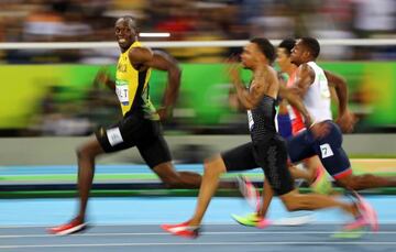 Usain Bolt sonre mientras corre la semifinal de los 100 metros.