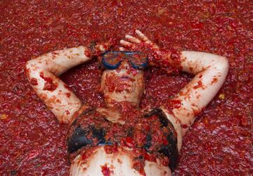 A reveller covered in tomato pulp takes part in the annual "Tomatina" festival in the eastern town of Bunol, on August 30, 2017.
The iconic fiesta -- which celebrates its 72nd anniversary and is billed at "the world's biggest food fight" -- has become a major draw for foreigners, in particular from Britain, Japan and the United States. / AFP PHOTO / JAIME REINA