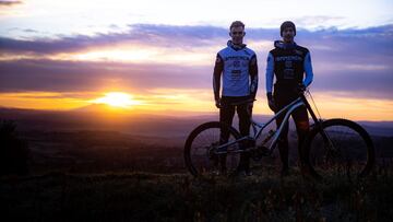 Los pilotos de MTB Pau Menoyo y &Aacute;ngel Su&aacute;rez, posando junto a la Commencal Suprem, bici con la que competir&aacute;n en la UCI MTB World Cup de DH con el nuevo equipo Commencal 21. Al fondo, la pueta de sol y algunas nubes. 