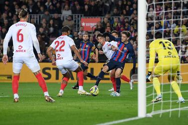Gavi controla el balón ante la oposición de Oliver Torres y Loic Bade dentro del área del Sevilla.