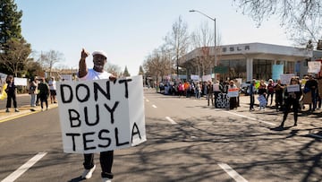 FILE PHOTO: People protest against Tesla and Elon Musk outside of a Tesla dealership in Palo Alto, California, U.S., March 8, 2025. REUTERS/Laure Andrillon/File Photo