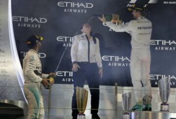 Nico Rosberg y Lewis Hamilton celebran sus respectivas victorias con una de las azafatas del podio.