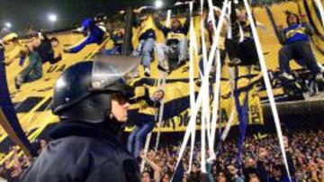 Un polic&iacute;a observa a hinchas del Boca Juniors en la Bombonera.