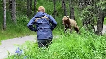 Un gu&iacute;a de monta&ntilde;a con el pelo rubio se encuentra con un oso grizzly en el camino en Alaska (Estados Unidos).