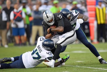 EJ Manuel (3) QB suplente de los Oakland Raiders, es tacleado por David Bass (47) y Marcus Smith (97), de los Seattle Seahawks.