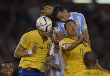 Argentina's Ramiro Funes (C) vies with Brazil's David(L) and Luiz Ricardo Oliveira(9) during their Russia 2018 FIFA World Cup South American Qualifiers football match, in Buenos Aires, on November 13, 2015. AFP PHOTO / JUAN MABROMATA