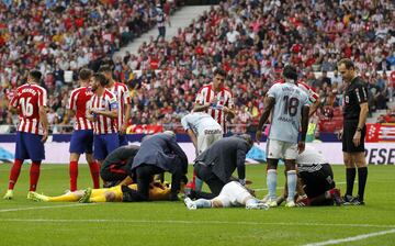 El jugador del Celta, Santi Mina y el portero del Atlético de Madrid, Oblak, son atendidos por los servicios médicos tras el fuerte choque.