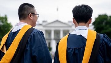 Students from George Washington University wear their graduation gowns outside of the White House.