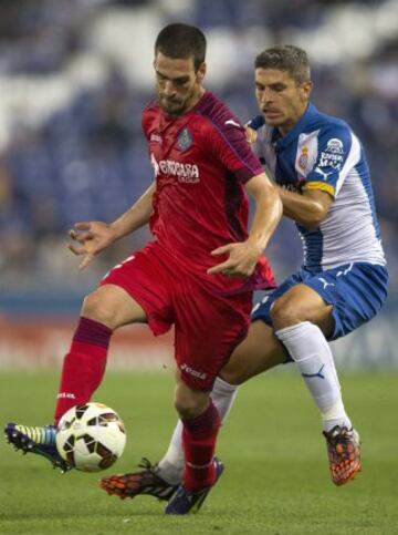 El centrocampista del Espanyol Salvador Sevilla López y el defensa del Getafe Álvaro Arroyo luchan por el balón durante el partido correspondiente a la quinta jornada de Liga que disputan en el Power8 Stadium de Cornellá.