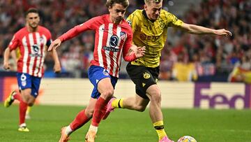 Dortmund's Norwegian defender #26 Julian Ryerson (R) fights for the ball with Atletico Madrid's French forward #07 Antoine Griezmann during the UEFA Champions League quarter final first leg football match between Club Atletico de Madrid and Borussia Dortmund at the Metropolitano stadium in Madrid on April 10, 2024. (Photo by JAVIER SORIANO / AFP)