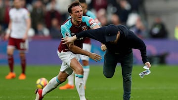 Un jugador del West Ham empuja a un aficionado que invadi&oacute; el campo durante un West Ham United vs Burnley de la Premier League. 