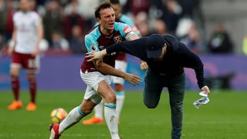 Un jugador del West Ham empuja a un aficionado que invadi&oacute; el campo durante un West Ham United vs Burnley de la Premier League. 