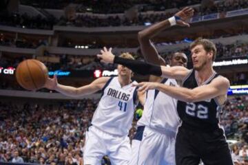 Tiago Splitter (22) pasa el balón ante Samuel Dalembert (1) and forward Dirk Nowitzki (41).