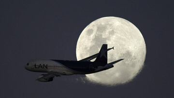 A LATAM Airlines airplane is seen flying before the moon after taking-off from Jorge Newbery airport in Buenos Aires on July 15, 2019. - The Chilean-Brazilian airline LATAM announced on June 17 that its subsidiary in Argentina will cease operations for an