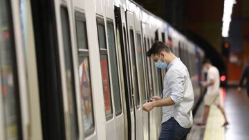 Un pasajero abre la puerta de un tren de Metro de Madrid.