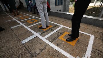 People stand on social distancing markers at an automation teller machine (ATM) at First Bank Nigeria Plc, following the outbreak of the coronavirus disease (COVID-19), in Abuja, Nigeria May 6, 2020. Picture taken May 6, 2020. REUTERS/Afolabi Sotunde