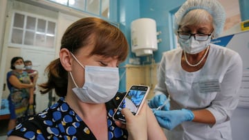 Una mujer filma en un tel&eacute;fono mientras le inyectan la vacuna Sputnik Light contra la enfermedad del coronavirus (COVID-19) en un hospital local en la ciudad de Donetsk, Ucrania, controlada por los rebeldes, el 2 de agosto de 2021.