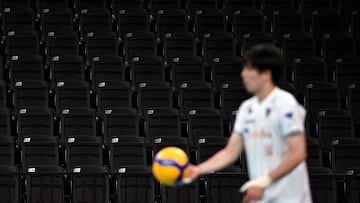 A player prepares to serve a ball in front of empty seats at Ariake Arena in Tokyo on July 23, 2021, ahead of the start of the Tokyo 2020 Olympic Games. (Photo by Angela Weiss / AFP)