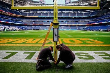 Workers adapt the Bernabéu for the NFL game between the Miami Dolphins and the Washington Commanders.