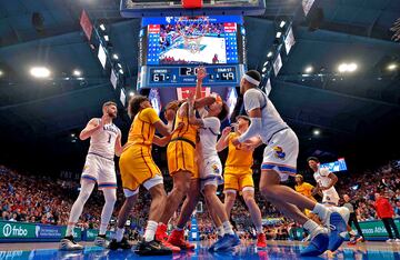 Una cmara situada a ras de suelo capt esta curiosa imagen durante el partido entre los Kansas Jayhawks y los Iowa State Cyclones de la Liga Universitaria de baloncesto de Estados Unidos (NCAA). Dishon Jackson y Zeke Mayo, en el centro, luchan por un rebote en el Allen Fieldhouse de Lawrence, Kansas. El partido acab 69-52 a favor de los locales.