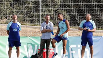 Lodi se lleva la mano atrás en la zona de banquillos, ante Andrea Berta, nada más retirarse de la sesión del Atlético.