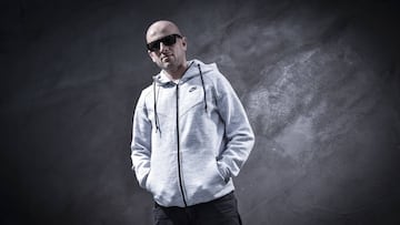 Carlos Dom&iacute;nguez &#039;Pity&#039; posando ante una pizarra negra con gafas de sol y sudadera gris de Nike.