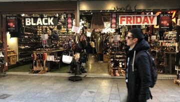 Hombre pasando por delante de una tienda en el &quot;Black Friday&quot;