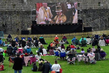 Decenas de personas siguien la ceremonia de coronación en el Castillo de Pembroke , Gales.