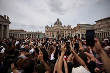 La gente usa sus teléfonos mientras el Papa León XIV aparece en el balcón central (Loggia delle Benedizioni) de la Basílica de San Pedro para dirigir la oración del Regina Caeli en el Vaticano.