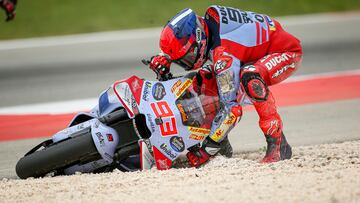 Marc Márquez levanta su moto tras el toque con Pecco Bagnaia, en el GP de Portugal.