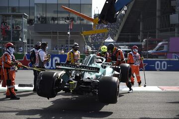 Los trabajadores retiran el autom¨®vil del piloto canadiense de Aston Martin, Lance Stroll, despu¨¦s de chocar durante la sesi¨®n de calificaci¨®n