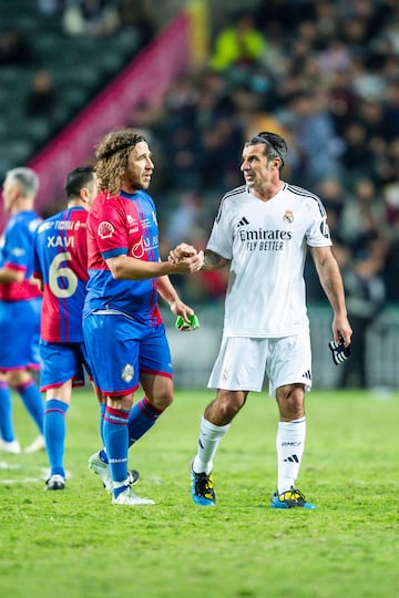 Puyol y Figo se saludan al final del partido.