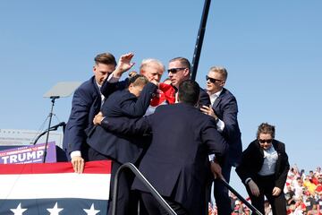 El expresidente, Donal Trump, es evacuado por el servicio secreto del estrado, con algo de sangre en el rostro, tras escucharse disparos. El candidato republicano ha salido por su propio pie con el pu?o en alto.
