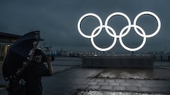 YOKOHAMA, JAPAN - JUNE 30: A man takes a photograph of the Olympic Rings at Akarenga Park on June 30, 2021 in Yokohama, Japan. With less than one month to go before the start of the Tokyo Olympic Games, final preparations are being made to venues despite 