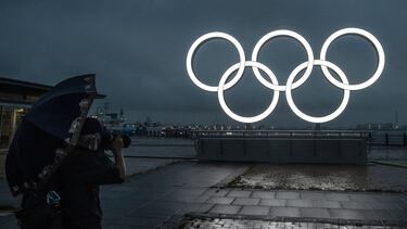 YOKOHAMA, JAPAN - JUNE 30: A man takes a photograph of the Olympic Rings at Akarenga Park on June 30, 2021 in Yokohama, Japan. With less than one month to go before the start of the Tokyo Olympic Games, final preparations are being made to venues despite