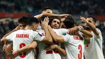 Iran's players celebrate with their forward #20 Sardar Azmoun after he scored their fourth goal during the Qatar 2023 AFC Asian Cup Group C football match between Iran and Palestine at the Education City Stadium in Al-Rayyan, west of Doha on January 14, 2024. (Photo by KARIM JAAFAR / AFP)