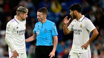 Real Madrid's Uruguayan midfielder Federico Valverde (L) and Real Madrid's Spanish midfielder Marco Asensio (R) speak with Spanish referee Alejandro Jose Hernandez Hernandez during the Spanish league football match between Real Madrid CF and Sevilla FC at the Santiago Bernabeu stadium in Madrid, on October 22, 2022. (Photo by JAVIER SORIANO / AFP)