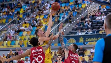 El ala-pívot español del Gran Canaria Miquel Salvó (2i) lanza a canasta ante Jeremy Morgan (i) y Maksim Salash (d), escolta estadounidense y pívot bielorruso del Mincidelice JL Bourg, durante el encuentro de la cuarta jornada de la Eurocopa entre Dreamland Gran Canaria y Mincidelice JL Bourg, este miércoles en el pabellón Gran Canaria Arena de Las Palmas.