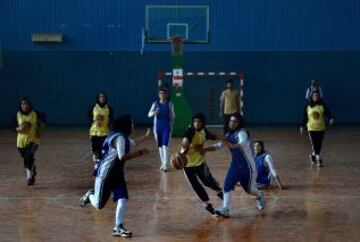 Las jugadoras de baloncesto afganas de la provincia de Herat (en amarillo) compiten con el equipo de Kabul, en un partido amistoso en el Estadio Olímpico Nacional de Kabul el 18 de septiembre de 2013.