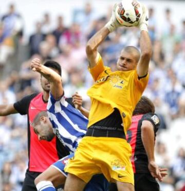 El portero del Almería Rubén Iván Martínez (d) para el balón ante el defensa del Deportivo de la Coruña Alberto Lopo durante el partido de la sexta jornada de Liga de Primera División, disputado esta tarde en el estadio de Riazor.