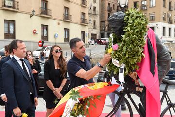 El exciclista Miguel Induráin coloca flores en la estatua de Federico Martín Bahamontes tras su fallecimiento.