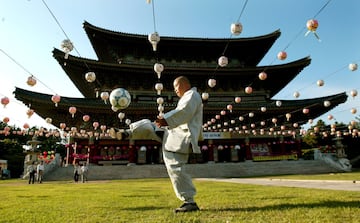 Un monje juega al fútbol cerca del templo de Yakcheonsa en la isla de Jeju.