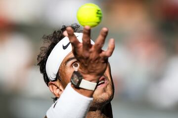 Nadal se prepara para realizar un saque en su partido de primera ronda de Wimbledon de 2022.